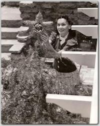 On the grounds of her lovely California home, Maureen decorates her 1939 Christmas tree.